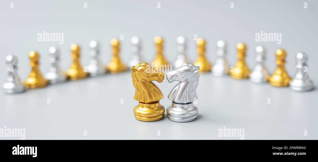 Gold and silver Chess Knight (horse) figure against pawn. Strategy, Conflict, management, business planning, tactic, politic, communication and leader Stock Photo