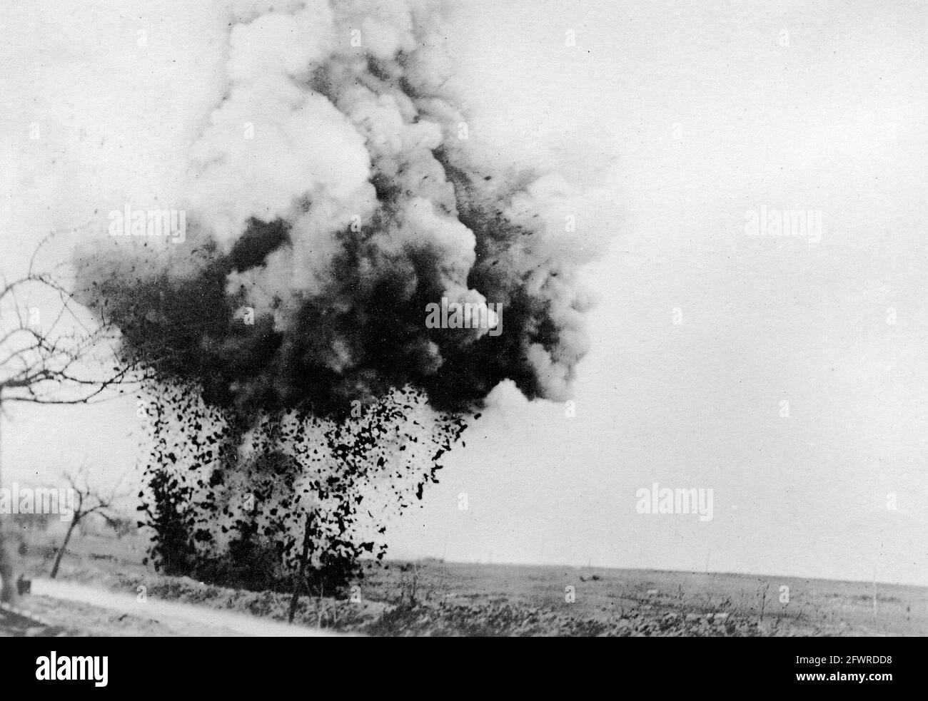 A large German high explosive shell bursting by the side of the road during the First World War. Stock Photo