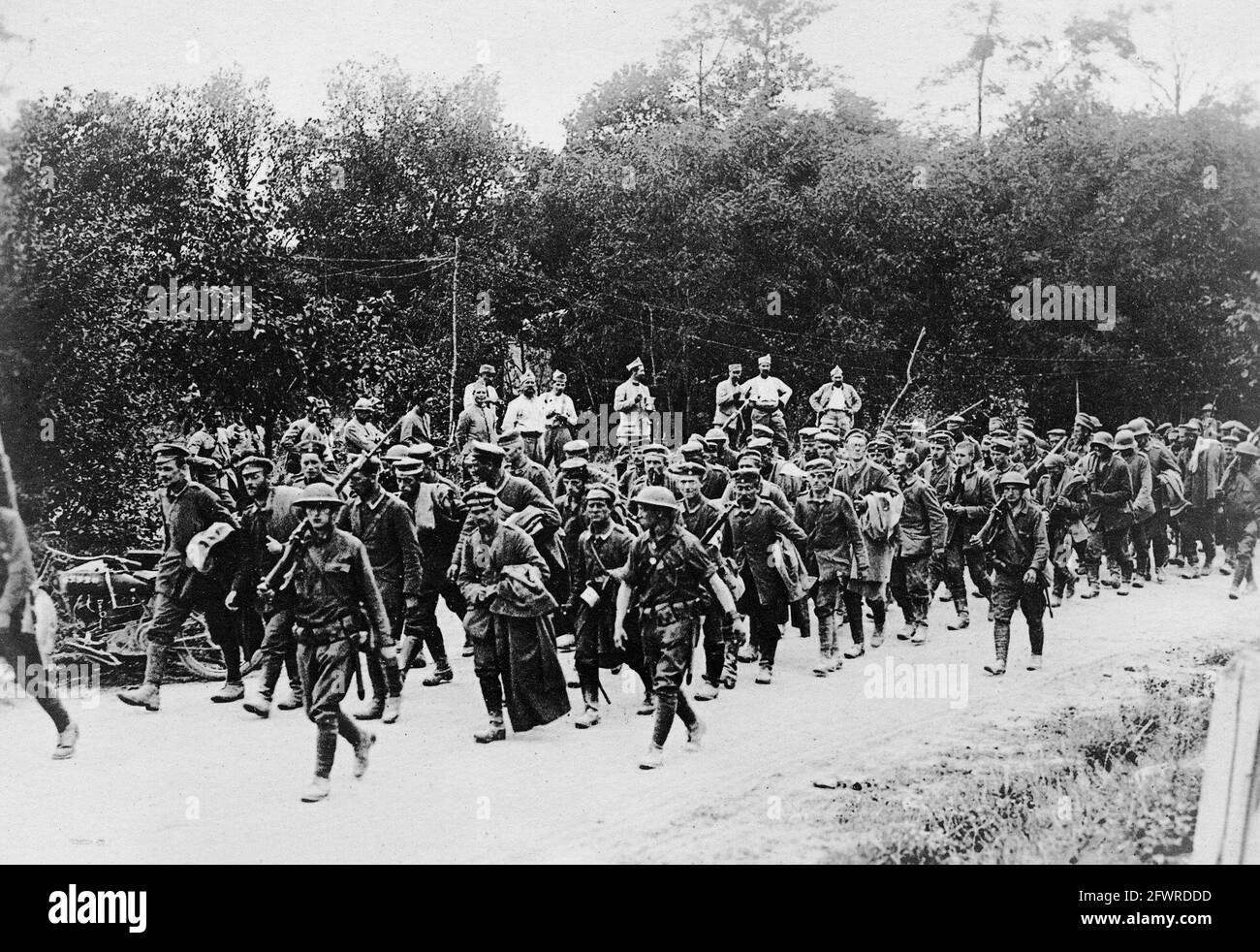 American soldiers escorting German prisoners to the rear, while French soldiers look on. France, 1918. Stock Photo