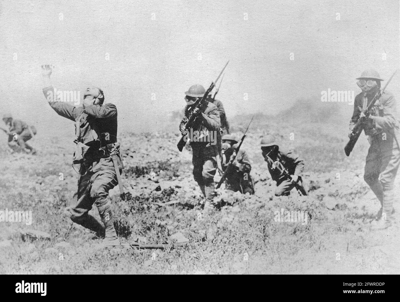 The effect of phosgene gas. American infantrymen wearing gas masks while advancing. The soldier in the foreground is suffering the effects of gas, having not put on his mask. Phosgene was responsible for 85% of chemical-weapons fatalities during the Great War. Stock Photo