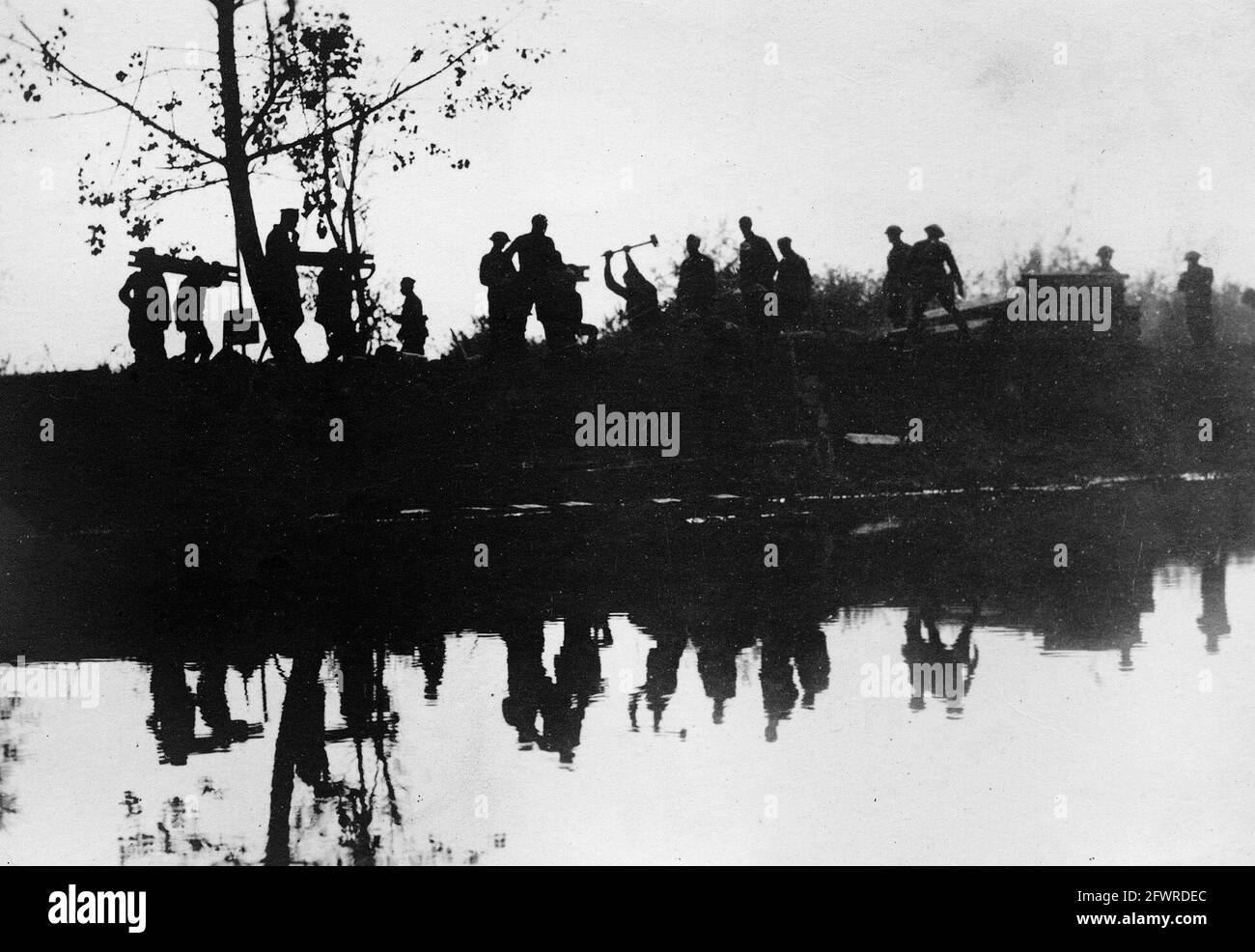 A silhouette image of a party of American Engineers constructing a pontoon bridge across the River Marne, during the Second Battle of the Marne, July-August 1918. Stock Photo