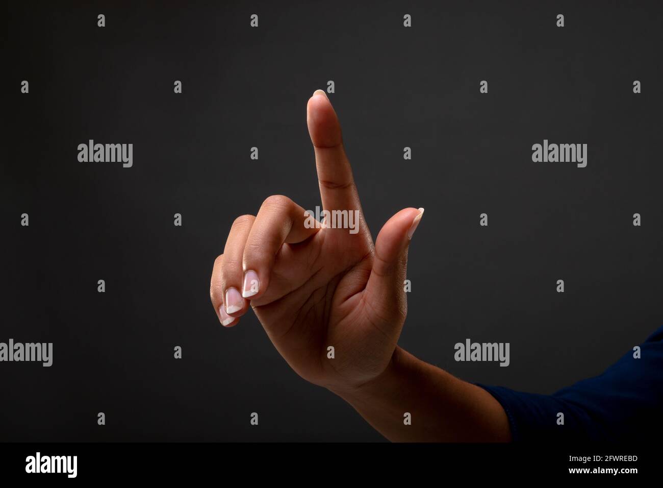 Close up of hands touching touching invisible screen against black background Stock Photo