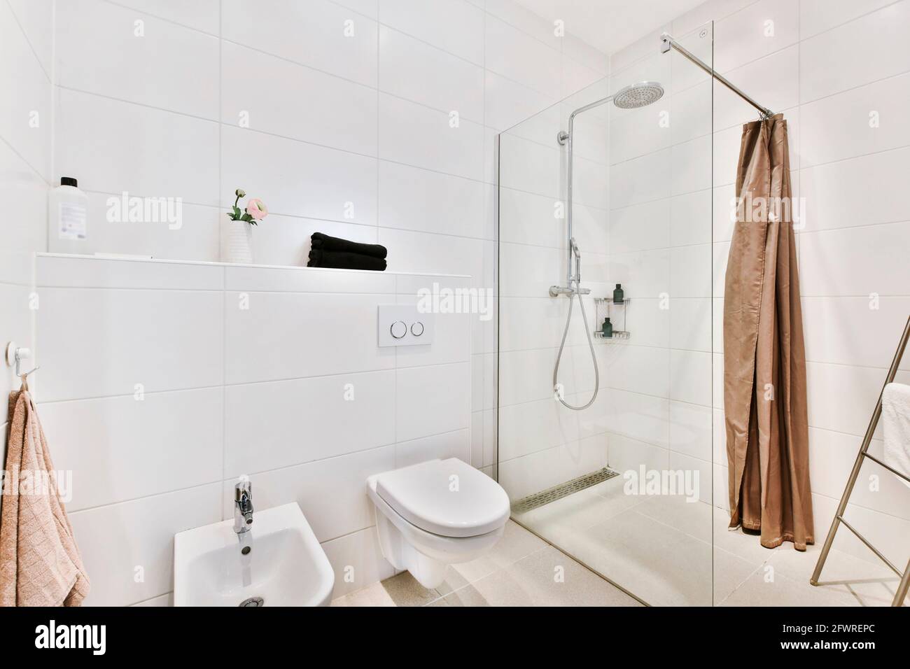 Modern interior of washroom with glass shower cabin and white hung wall ...