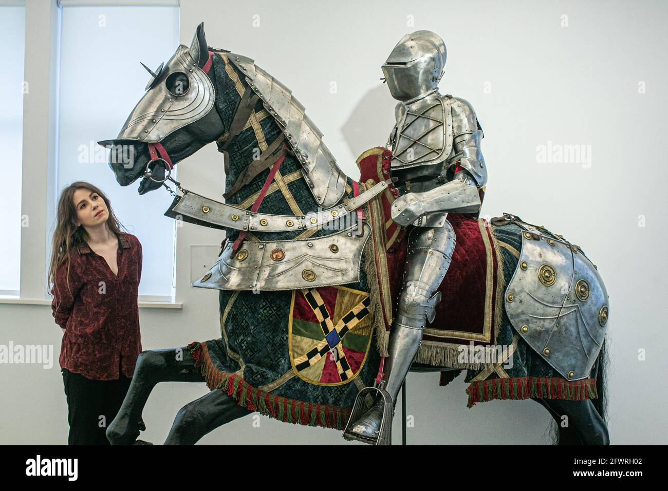 BONHAMS KNIGHTSBRIDGE LONDON 24 May 2021. Bonhams assistants pose with an equestrian full armour for man and horse in German late 16th century style during a preview of Bonhams Antique Arms and Armour Sale. Built as an accurate reproduction inspired by two sets of armours on display in the world-famous Wallace Collection in London, this armour is an impressive, decorative example of a type that has not come onto the market since the 19th century. Estimate: £15,000 – 20,000. The sale will take place on 26 May at Bonhams Knightsbridge. Credit amer ghazzal/Alamy Live News Stock Photo