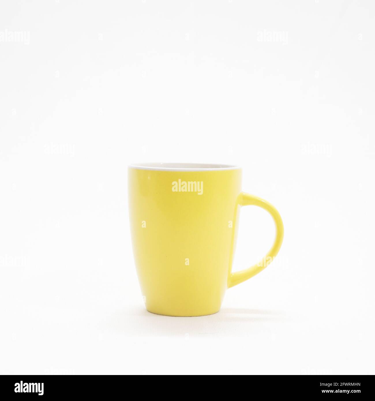 plain and simple yellow coffee mug isolated in a white background Stock Photo