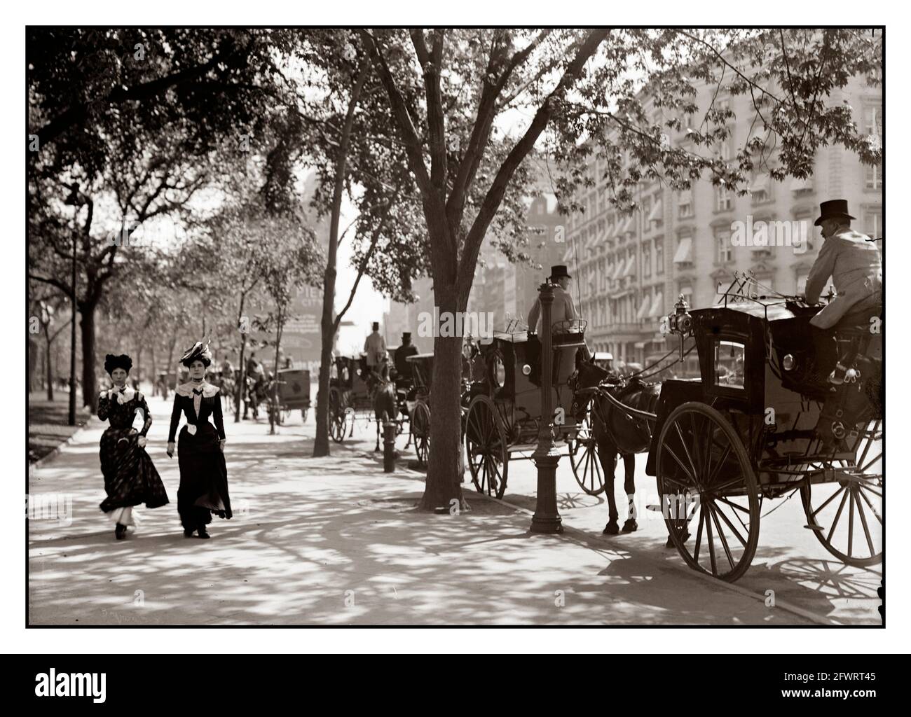 Vintage 1900s New York Horse Drawn Cab stand at Madison Square New York City with stylish ladies on the sidewalk 1900's USA America Stock Photo