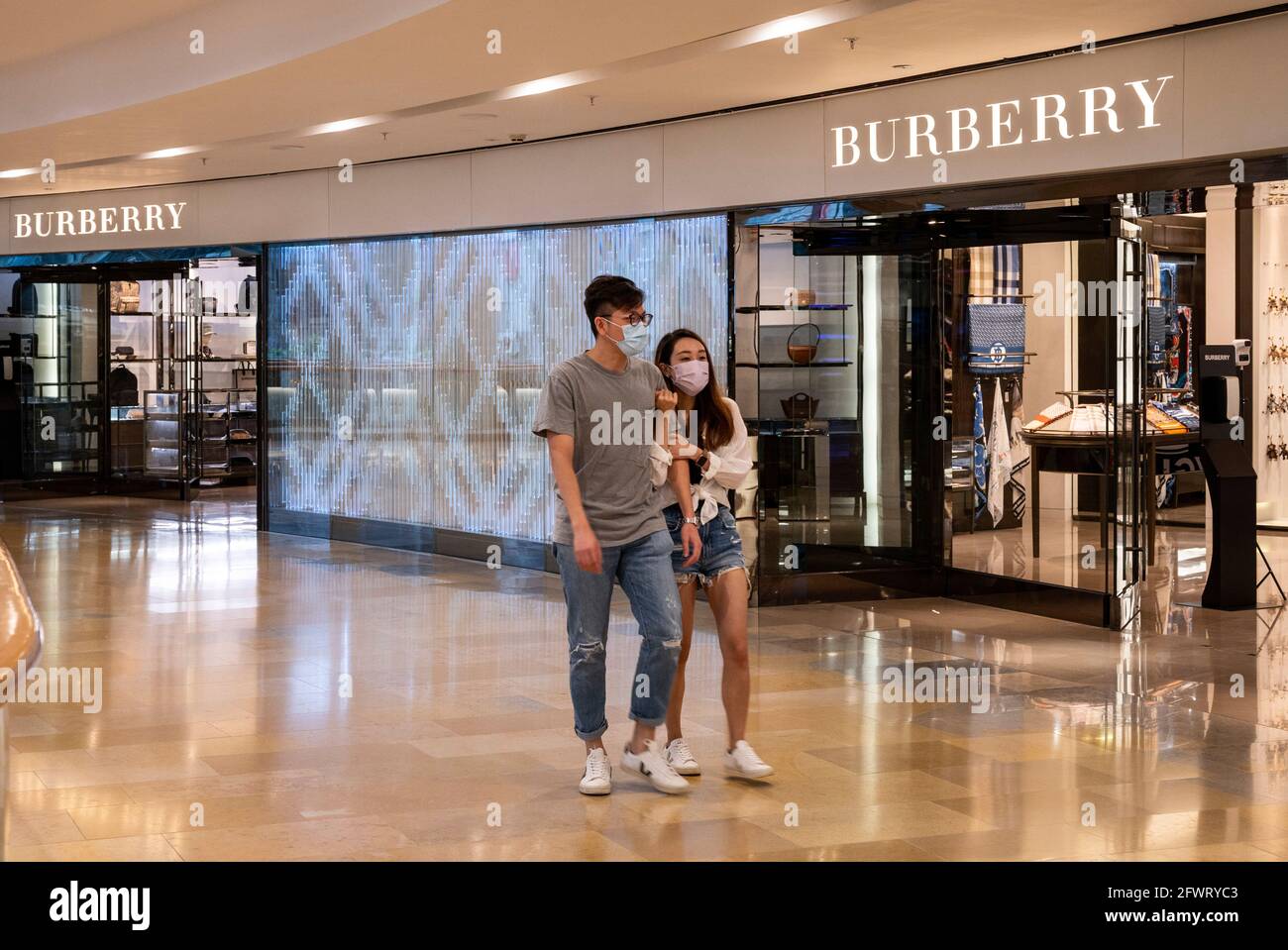A couple walks past the British luxury fashion brand Burberry store in Hong  Kong Stock Photo - Alamy