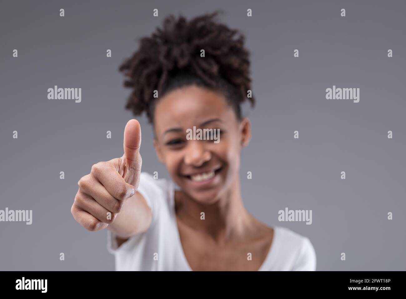 Happy smiling young Black teenage girl giving a thumbs up gesture of ...