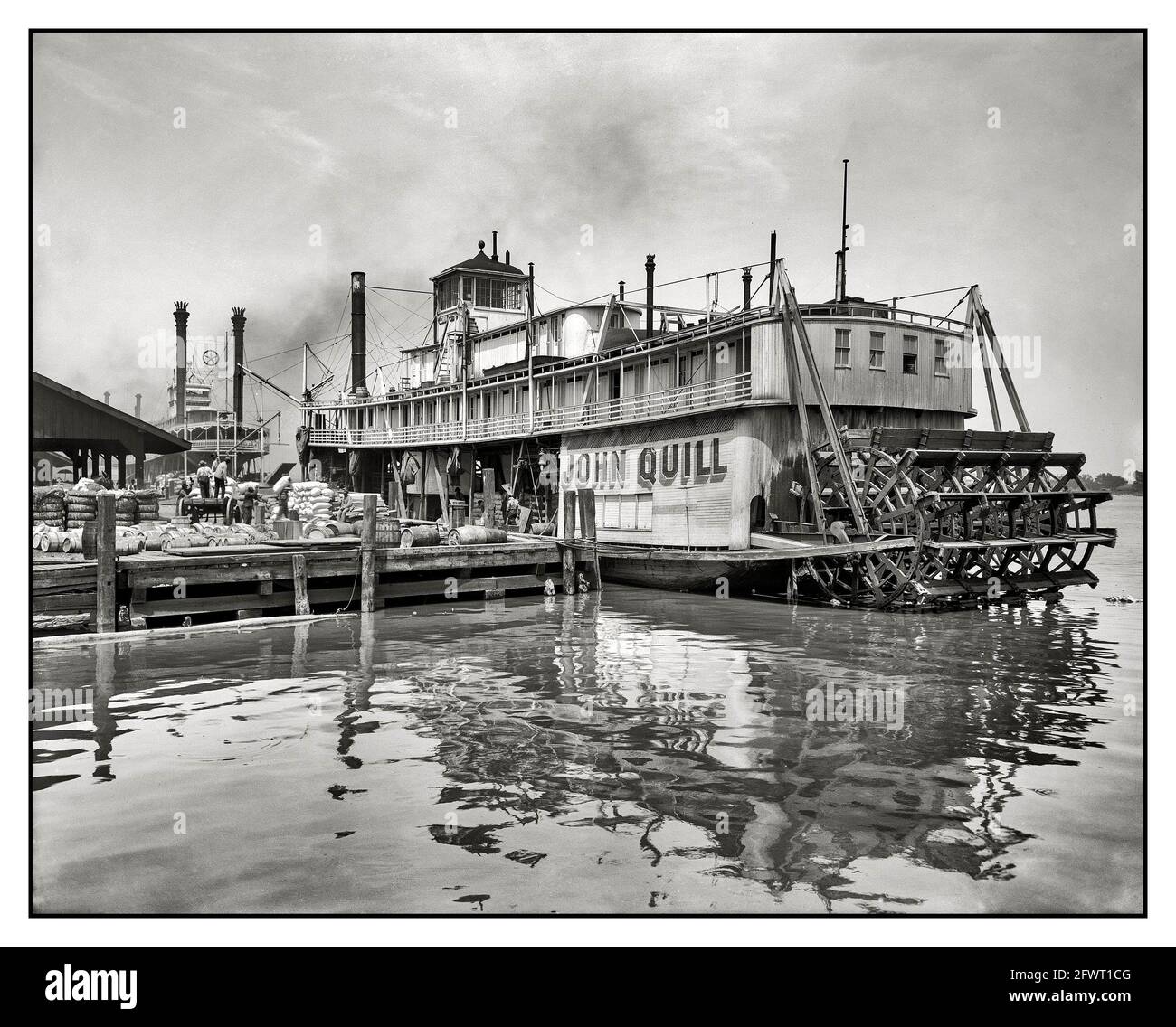 Packet Steamer Circa 1910. 'Sternwheeler John Quill, packet steamer.' She ran deliveries primarily the Tombigbee and Warrior Rivers in Alabama above Mobile, where this photograph was taken. Built by the famous Howard Shipyard at Jeffersonville, Indiana, for her namesake in 1907, she served that stretch of river until towed to Twelve Mile Island on the Mobile River (just northeast of Mobile) and dismantled there in 1928.   Launched: 1907, Jeffersonville, Ind. by Howard Yard Destroyed: 1928, Feb., towed from Mobil to Twelve Mile Island Stock Photo