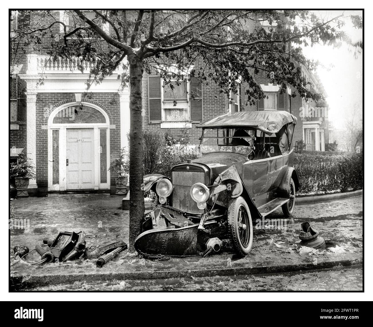1900's  Vintage historic Car accident crash into a tree and fire hydrant with frozen water and ice on the sidewalk pavement B&W image Stock Photo