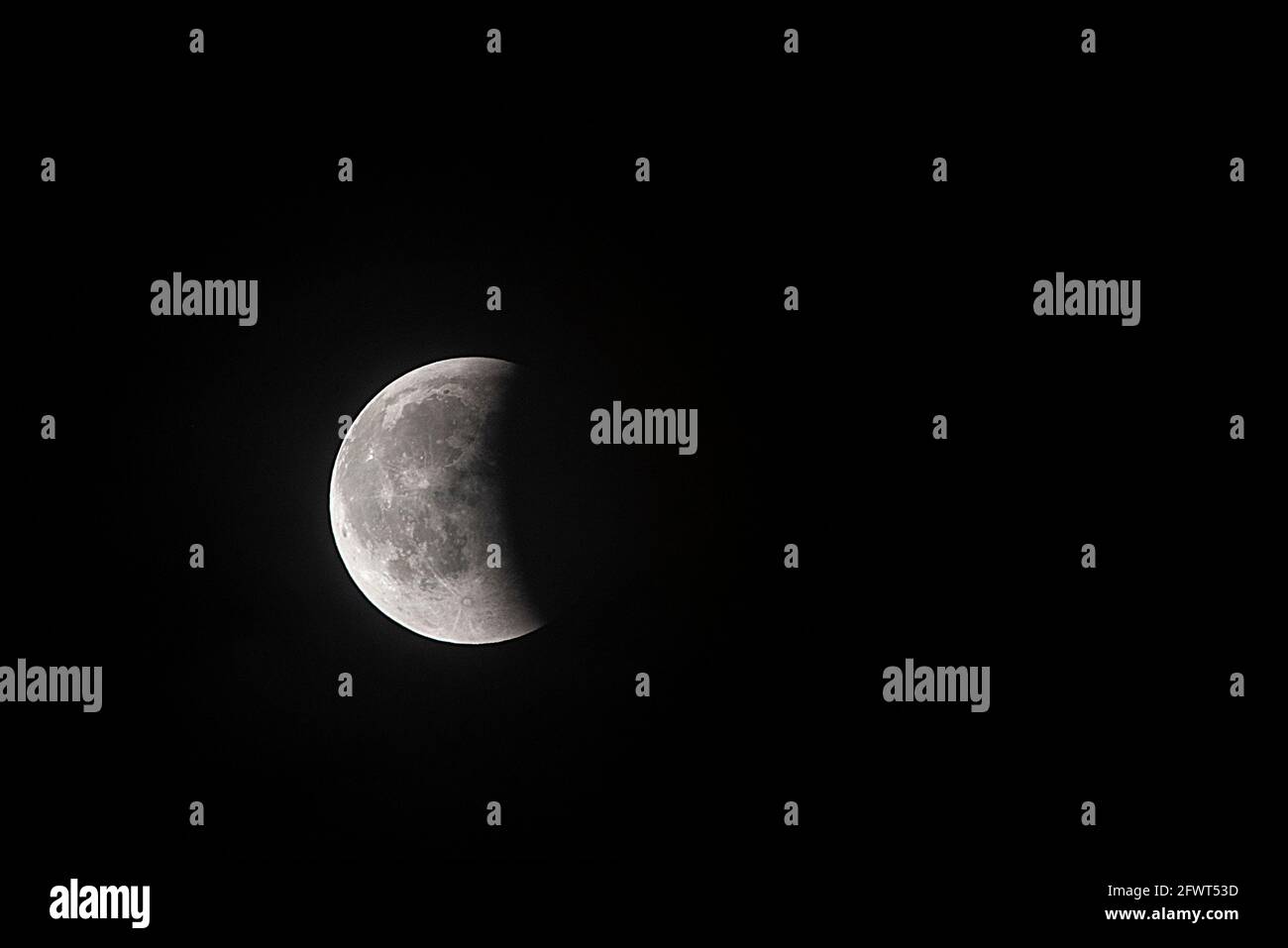 Partial lunar eclipse over the dark sky Stock Photo