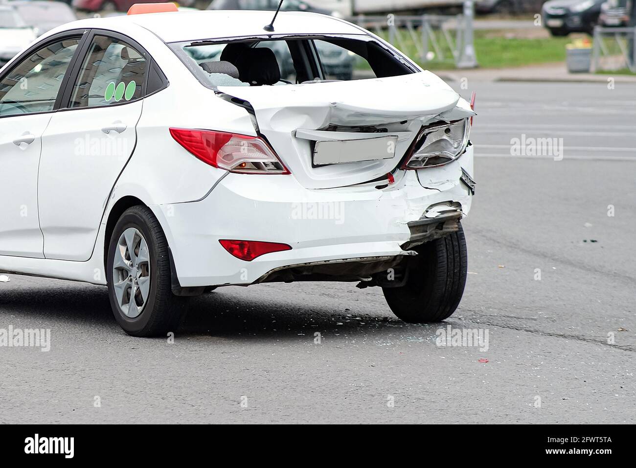 Collision of cars. The white taxi car suffered severe damage to the rear of the body. Broken