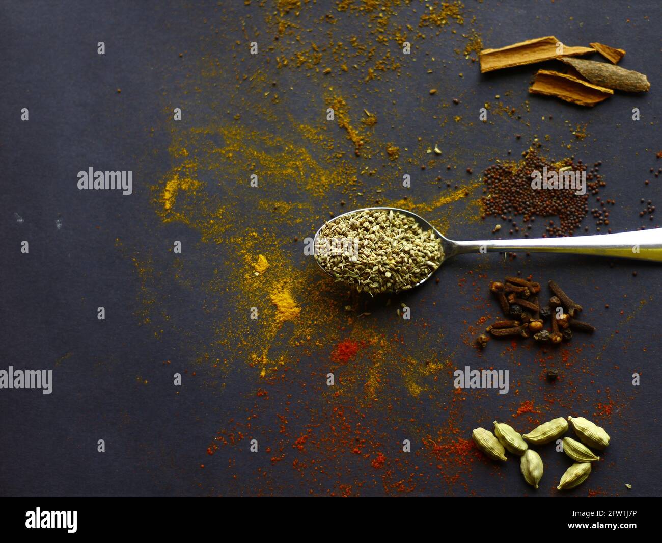 Indian spices, Cumin seeds on spoon, mustard seeds, cinnamon, cardamon