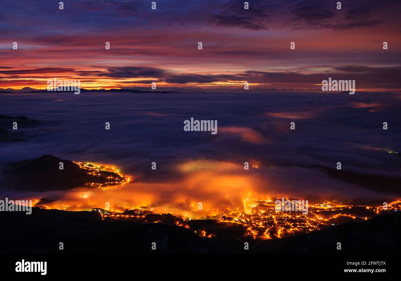 Berga city among fog, in the morning twilight - blue hour, seen from the Figuerassa viewpoint (Berguedà, Barcelona, Catalonia, Spain, Pyrenees) Stock Photo