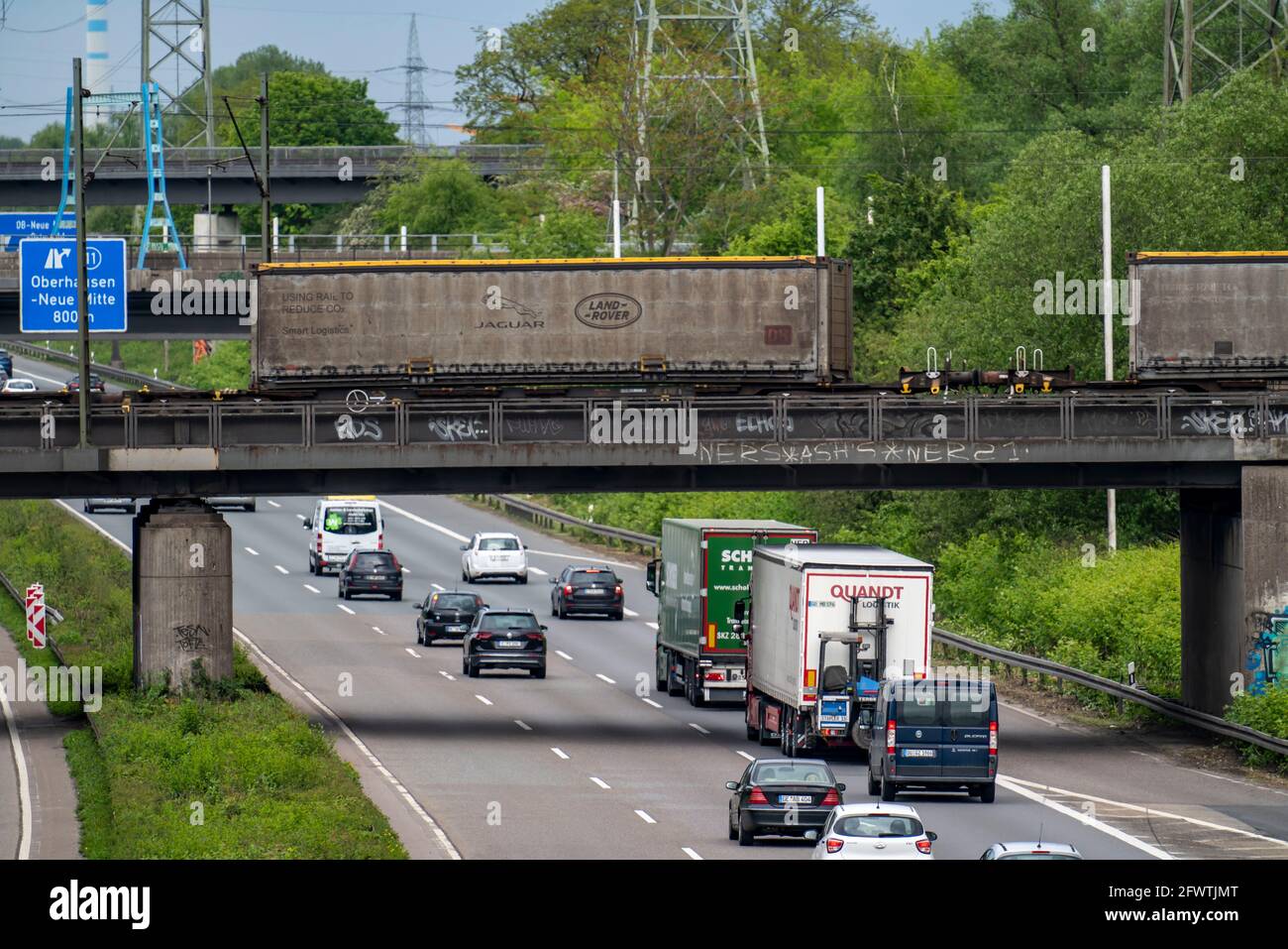 Truck traffic on the A42 motorway, Emscherschnellweg, railway bridge with goods train, Oberhausen, NRW, Germany Stock Photo