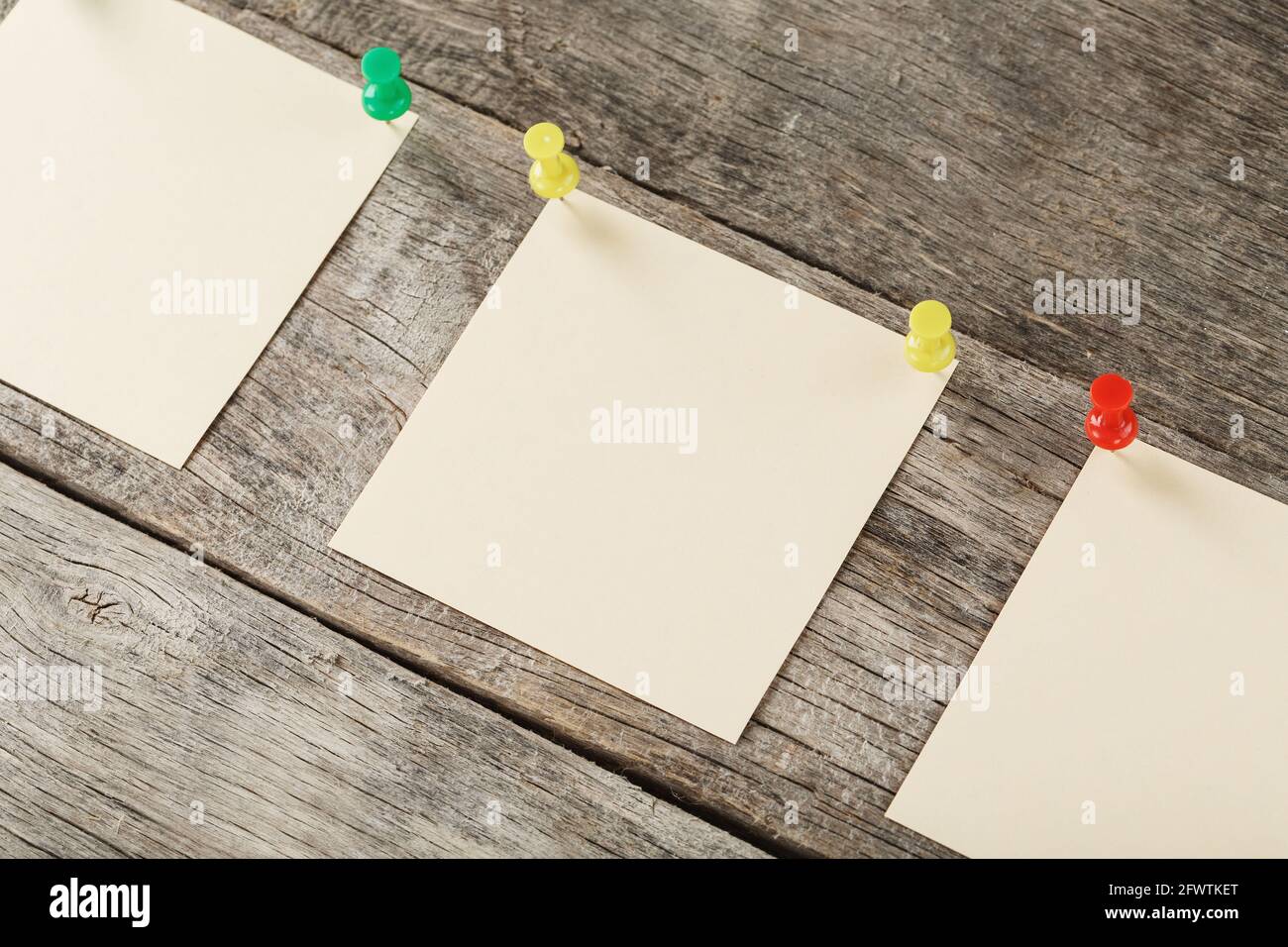 Sticky notes with pins in a row on a wooden background. Space for text, free space, top view Stock Photo