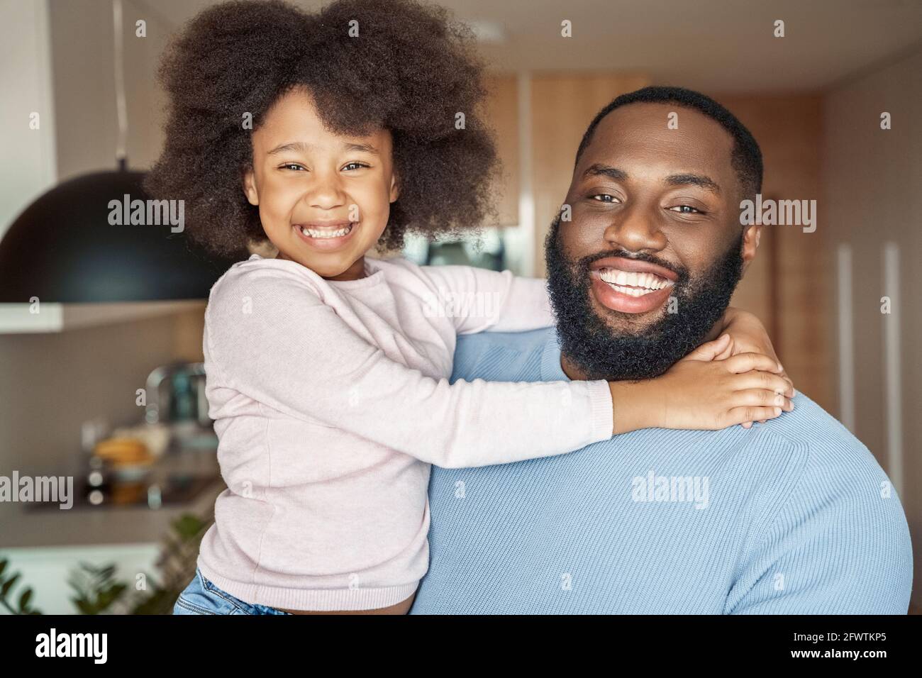 Toothy smiling happy young african american father and little daughter portrait Stock Photo