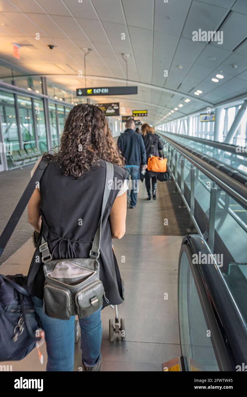 Lester Pearson airport, Toronto, Canada, February 2016 - Young woman behind other air travellers walking towards boarding gate for their flight  Stock Photo
