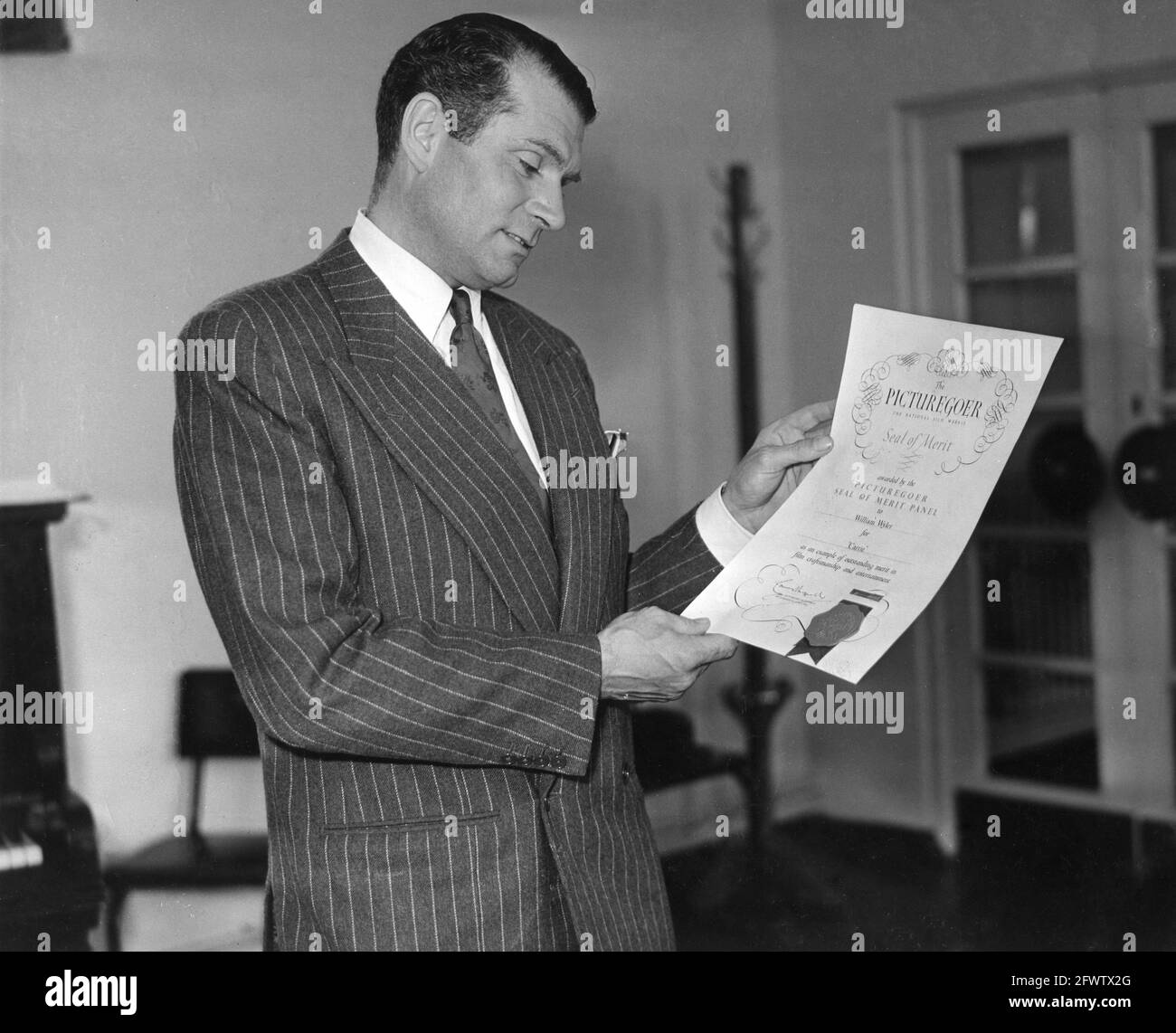 LAURENCE OLIVIER holding the Picturegoer Seal of Merit presented to William Wyler for his direction of CARRIE 1952 director WILLIAM WYLER from the novel Sister Carrie by Theodore Dreiser screenplay Ruth and Augustus Goetz music David Raksin costume design Edith Head Paramount Pictures Stock Photo