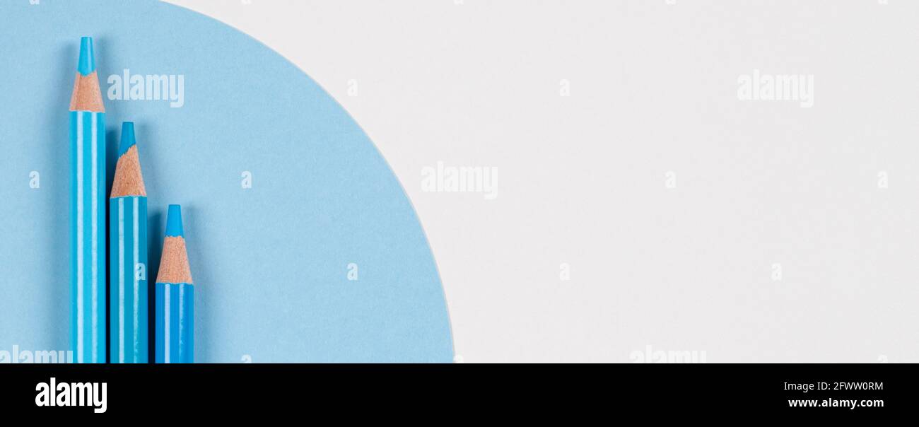 Light blue colored pencils on geometric blue and white background