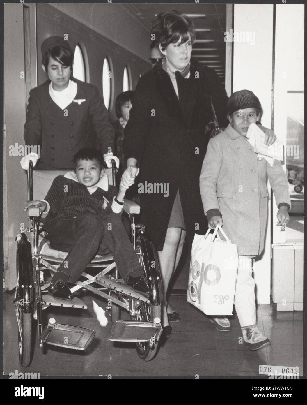 Three more children arrived at Schiphol Airport from Vietnam who had been seriously injured by the war there. The children, two girls and a boy, were brought to the Netherlands by the Terre des Hommes foundation. For the time being they are going to a clinic in Huizen (N.H.). Two of the three children at arrival at Schiphol Airport, in the chair the boy (injured by mine explosion) and on the right a girl (burns), February 27, 1968, wounded, health care, children, airports, The Netherlands, 20th century press agency photo, news to remember, documentary, historic photography 1945-1990, visual Stock Photo