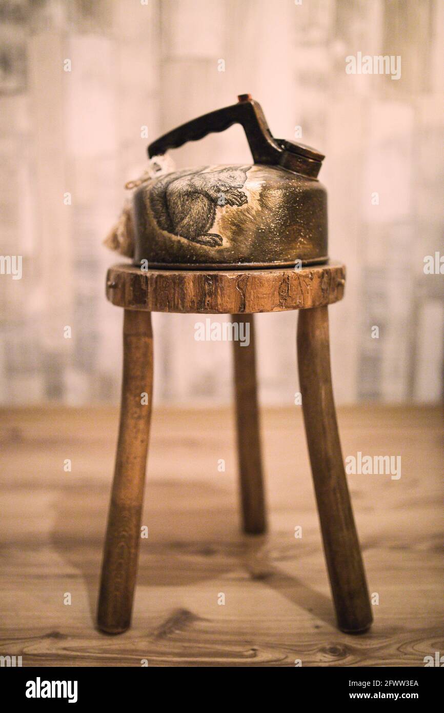 An old Rustic Teaspot on a tripod chair. Beautiful old details in the Rustic House. Stock Photo