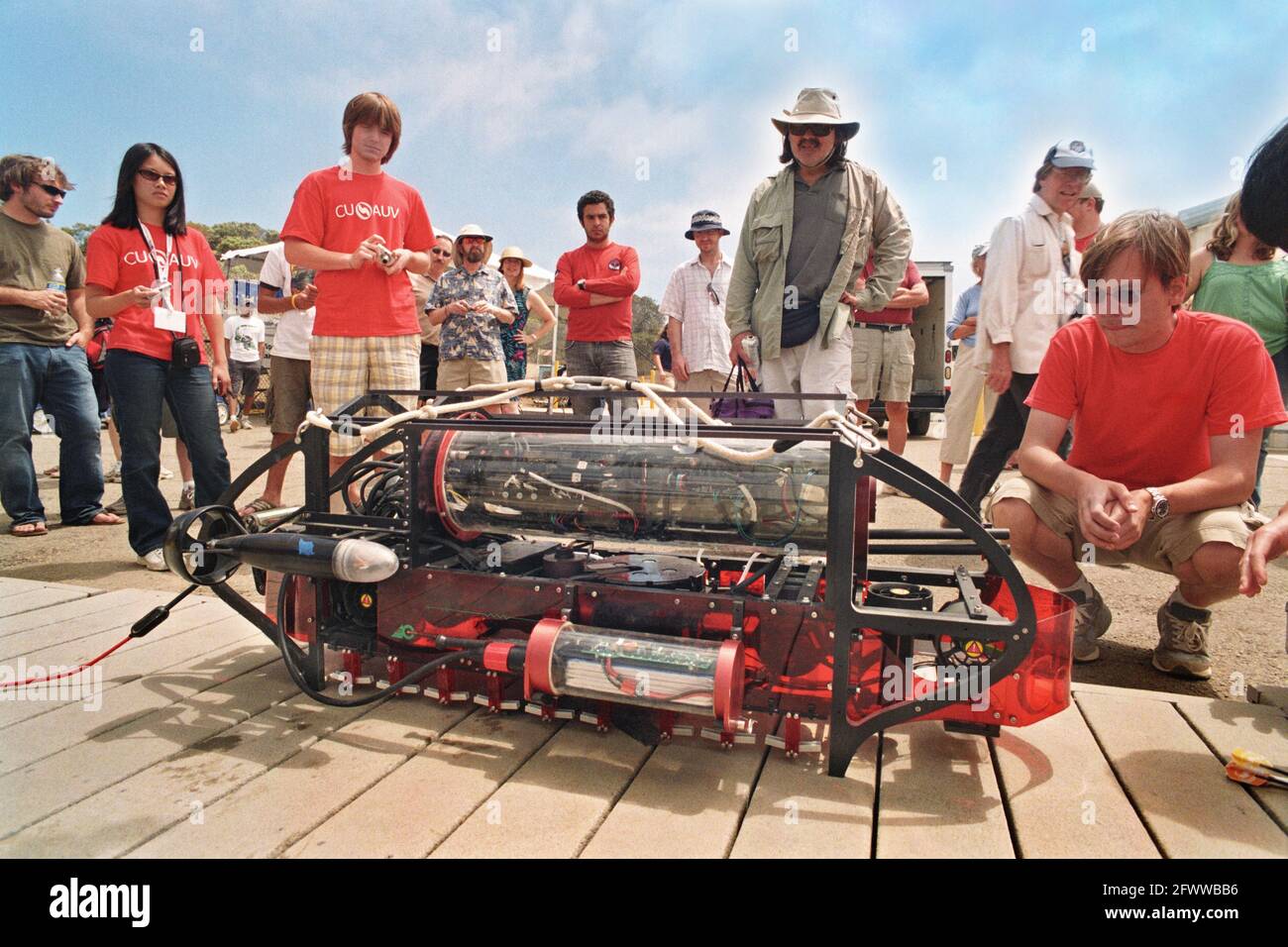 The Cornell University's 'Nova' 2009 Autonomous Underwater Vehicle (AUV); about to be weighed and hoisted into the water.  Red-shirted team-mates guard it like mother hens; as well they might. Victorious in 2003; they have been skunked ever since; up till now.  This test vehicle has been in the water every day since May. SPAWAR Transducer Test Facility; San Diego; 12th International Autonomous Underwater Vehicle Competition; sponsored by the Association for Unmanned Vehicle Systems International Stock Photo