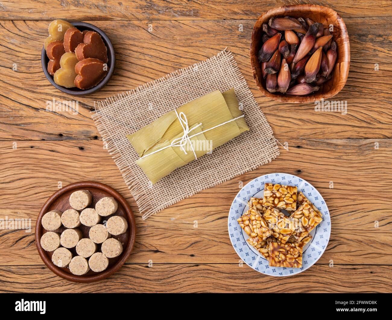 Typical brazilian june festival food. Pamonha, potato sweet, pine tree seed and peanut candy. Stock Photo