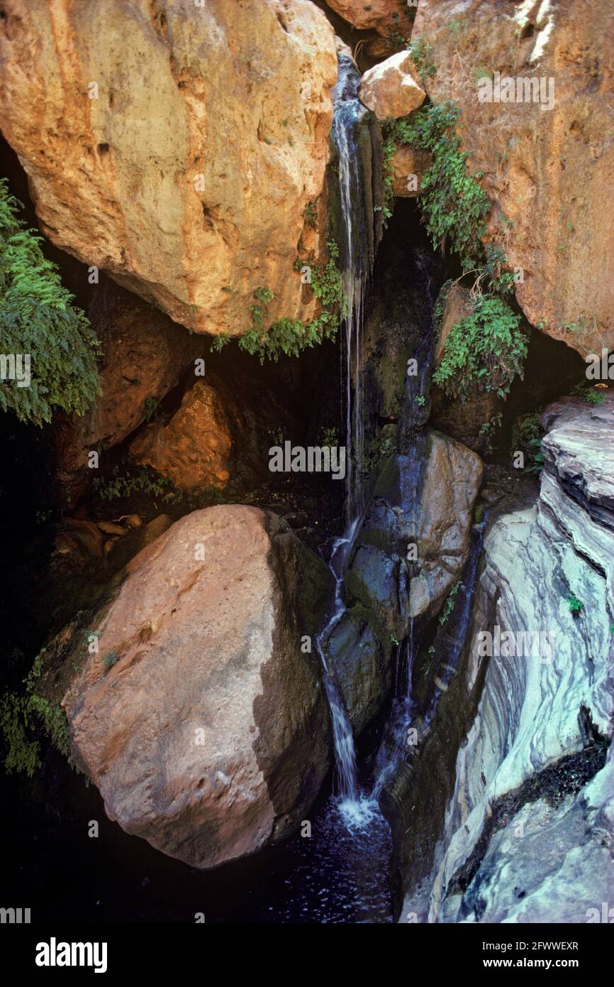 A waterfall in a slot canyon filled with boulders; Canyonlands of Utah; Stock Photo
