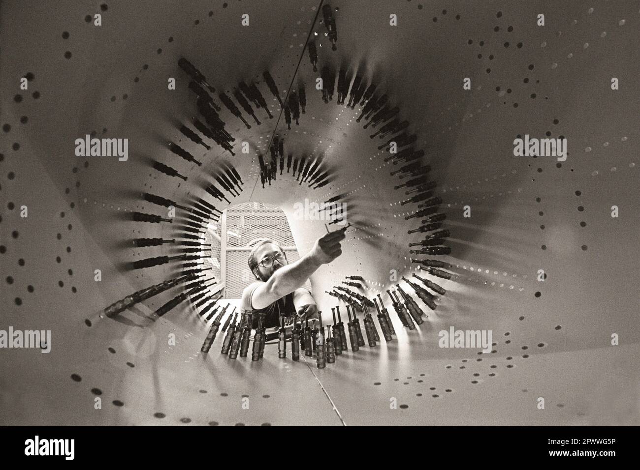 A worker installs rivets in an aircraft intake in the assembly line in