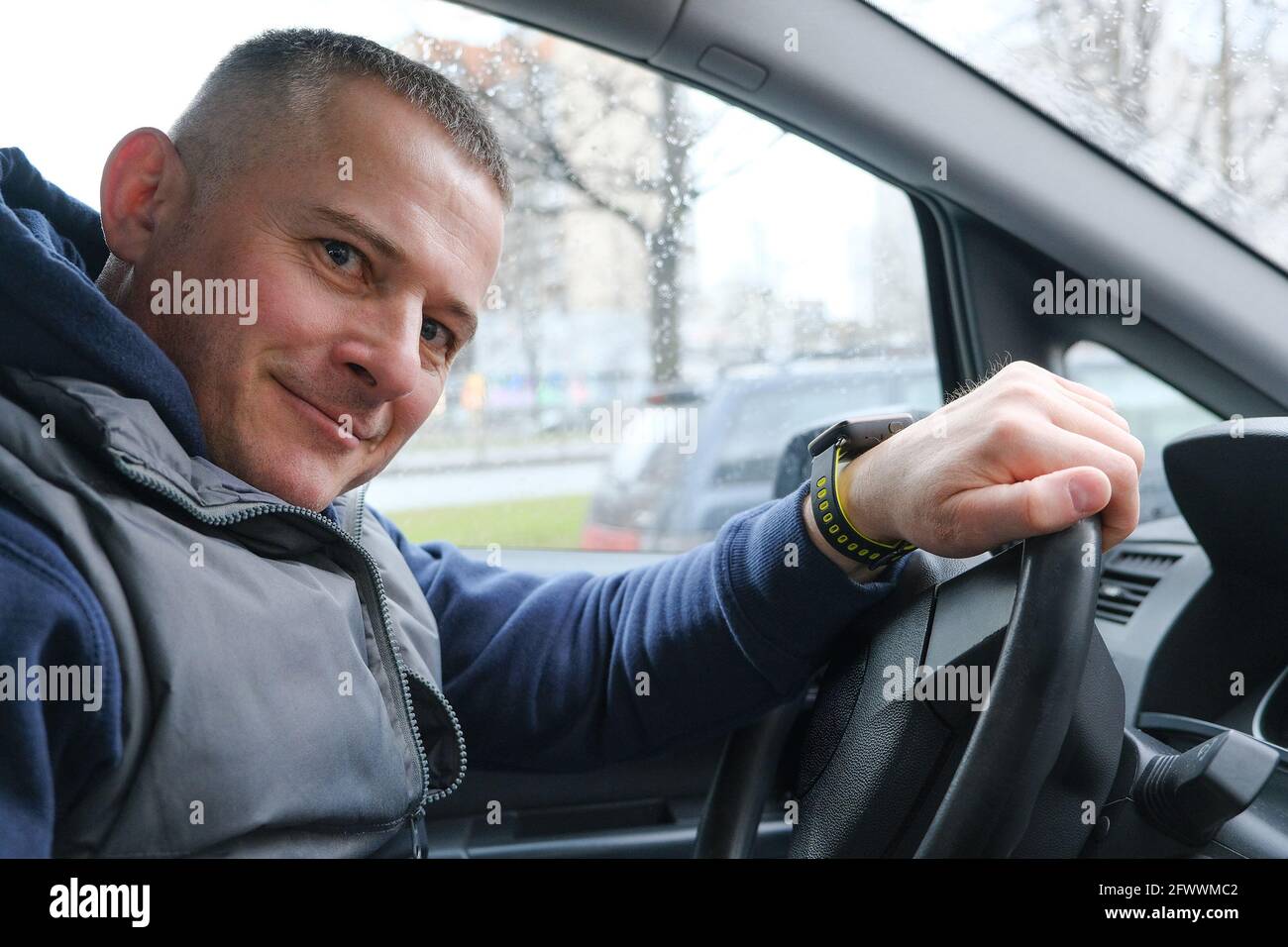 A smiling driver does not lose heart in a traffic jam being late for business. The concept of a philosophical attitude to life Stock Photo