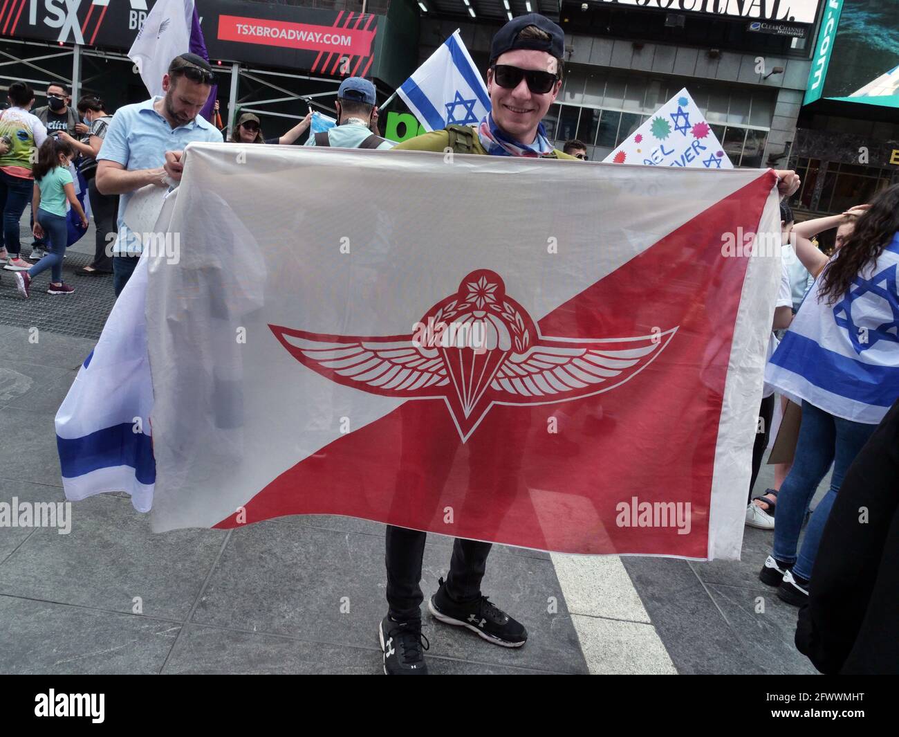 New York, New York, USA. 23rd May, 2021. Demonstrators at a Pro Israel Rally in Times Square Sunday afternoon. The official rally was cancelled at the last minute due to concerns for violence but these protesters showed up anyway to show their pro Israel support. A few Pro Palestine supporters showed up including Orthodox Jews that do not recognize the state of Israel. Protester holds flag insignia of Israel Paratroopers Credit: Milo Hess/ZUMA Wire/Alamy Live News Stock Photo