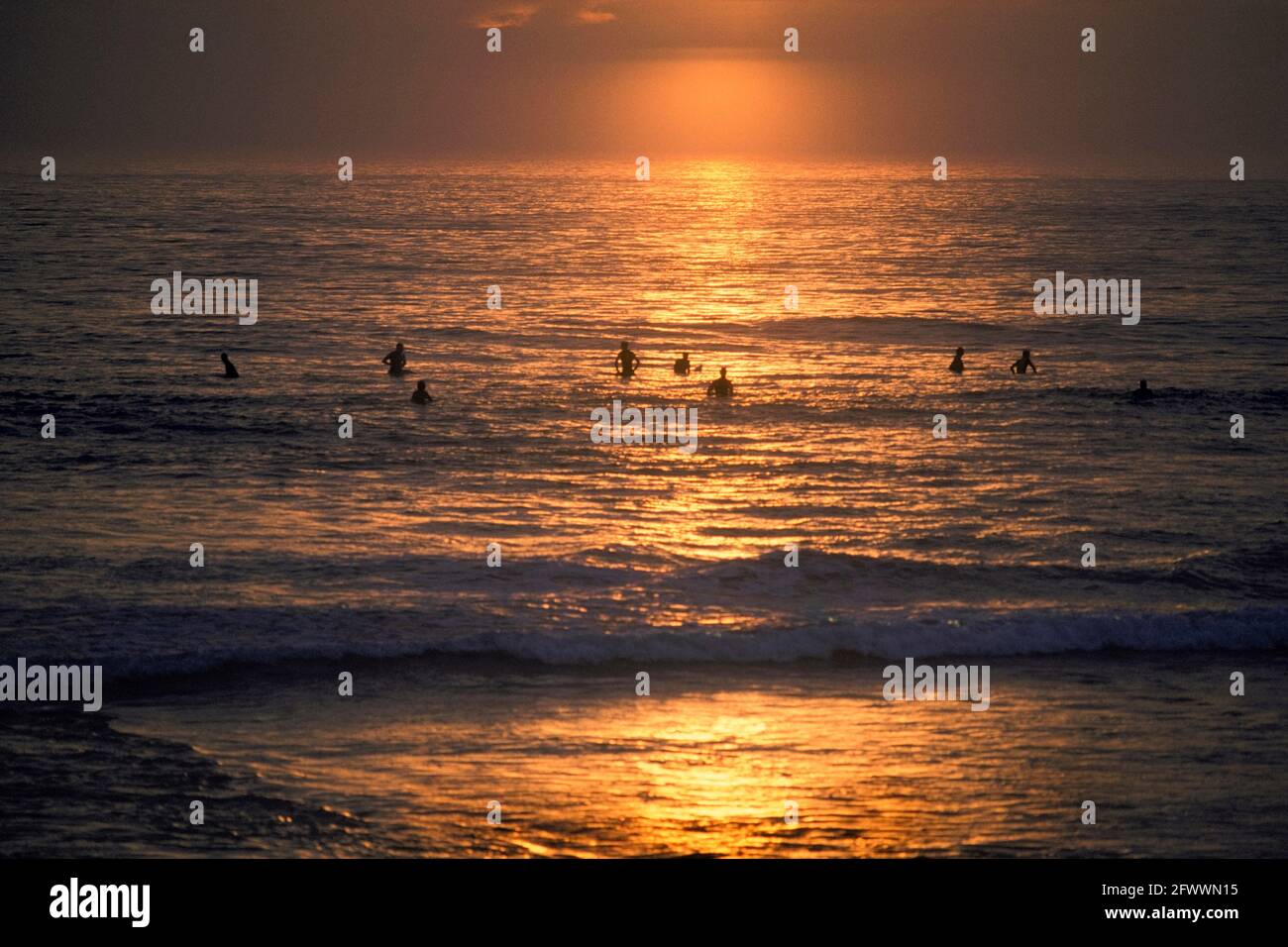 Hopeful Surfers At Sunset Stock Photo