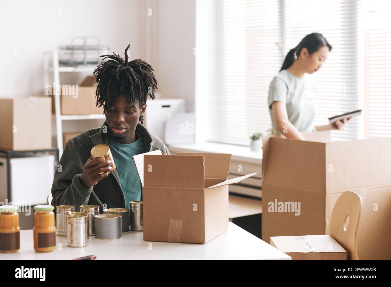 Adult african man packing boxes hi-res stock photography and images - Alamy