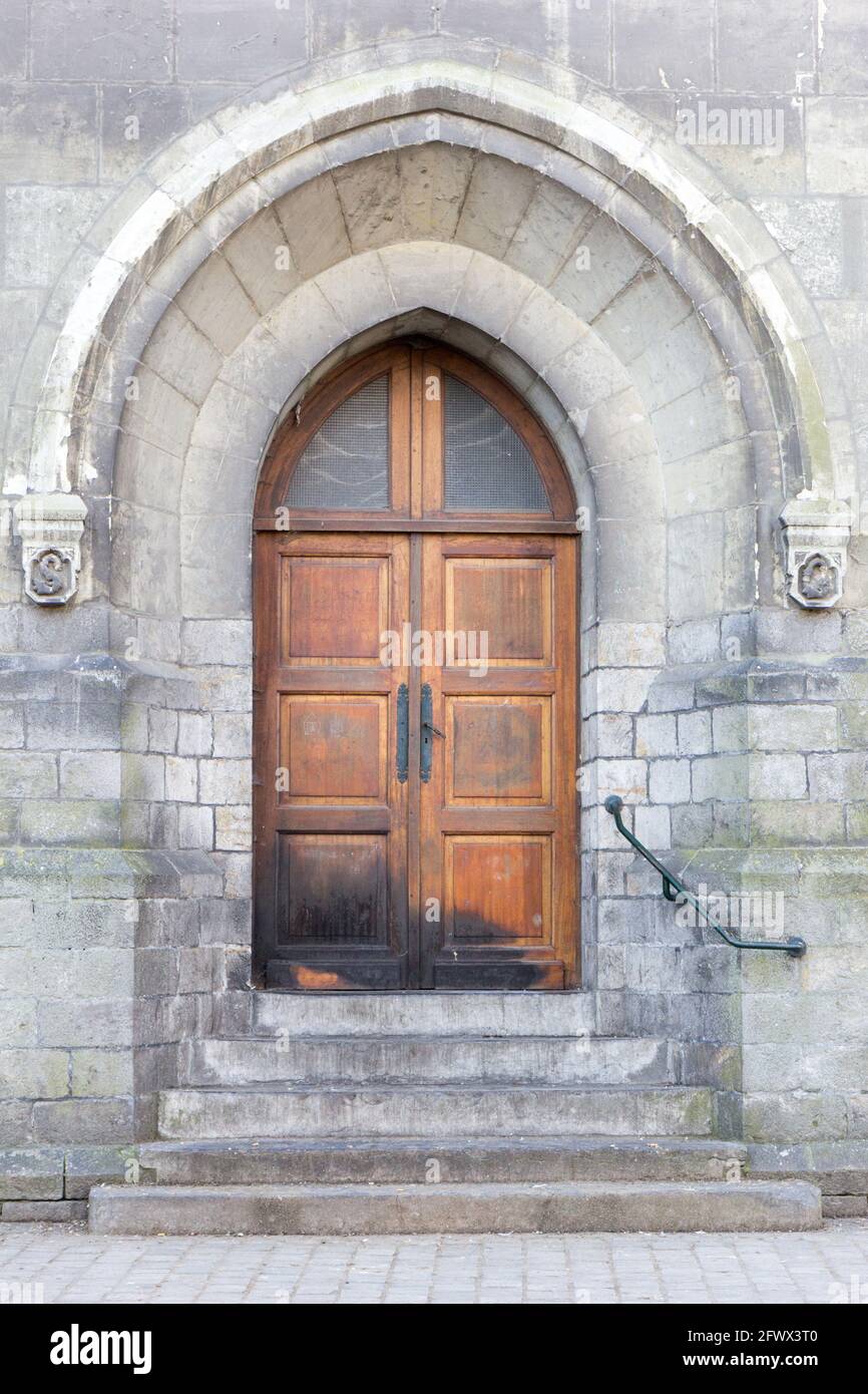 A gothic door with pointed arch on the gothic church of Saint Gery (Gaugericus) in Valenciennes. Stock Photo