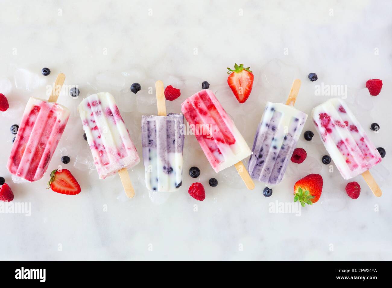 Group of assorted berry fruit yogurt ice pops. Top view in a row on a