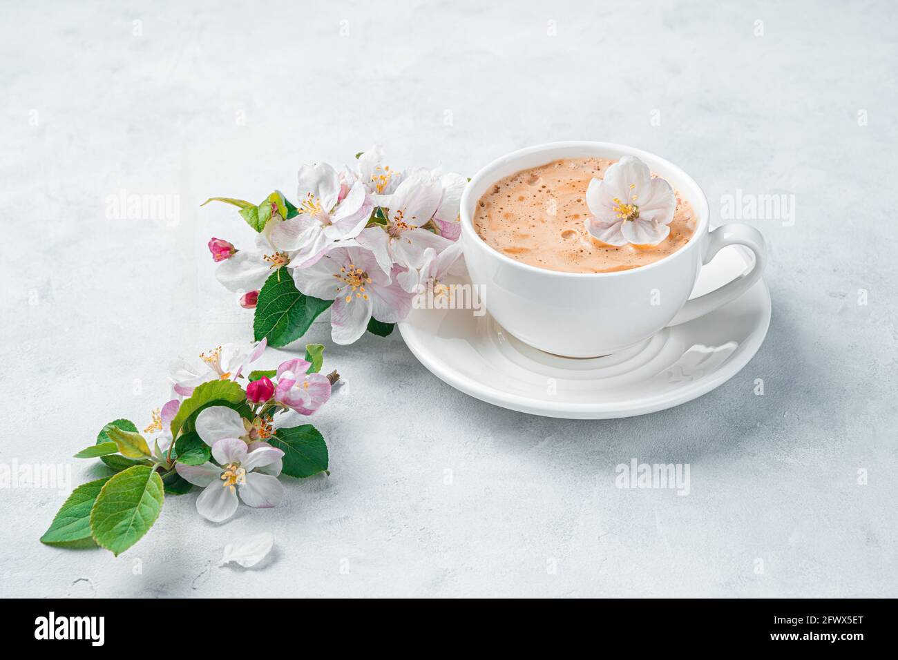 Fresh morning coffee and flowers on a light background. Side view ...