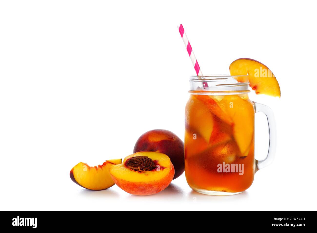 Summer peach iced tea in a mason jar glass with cut fruit isolated on a white background Stock Photo