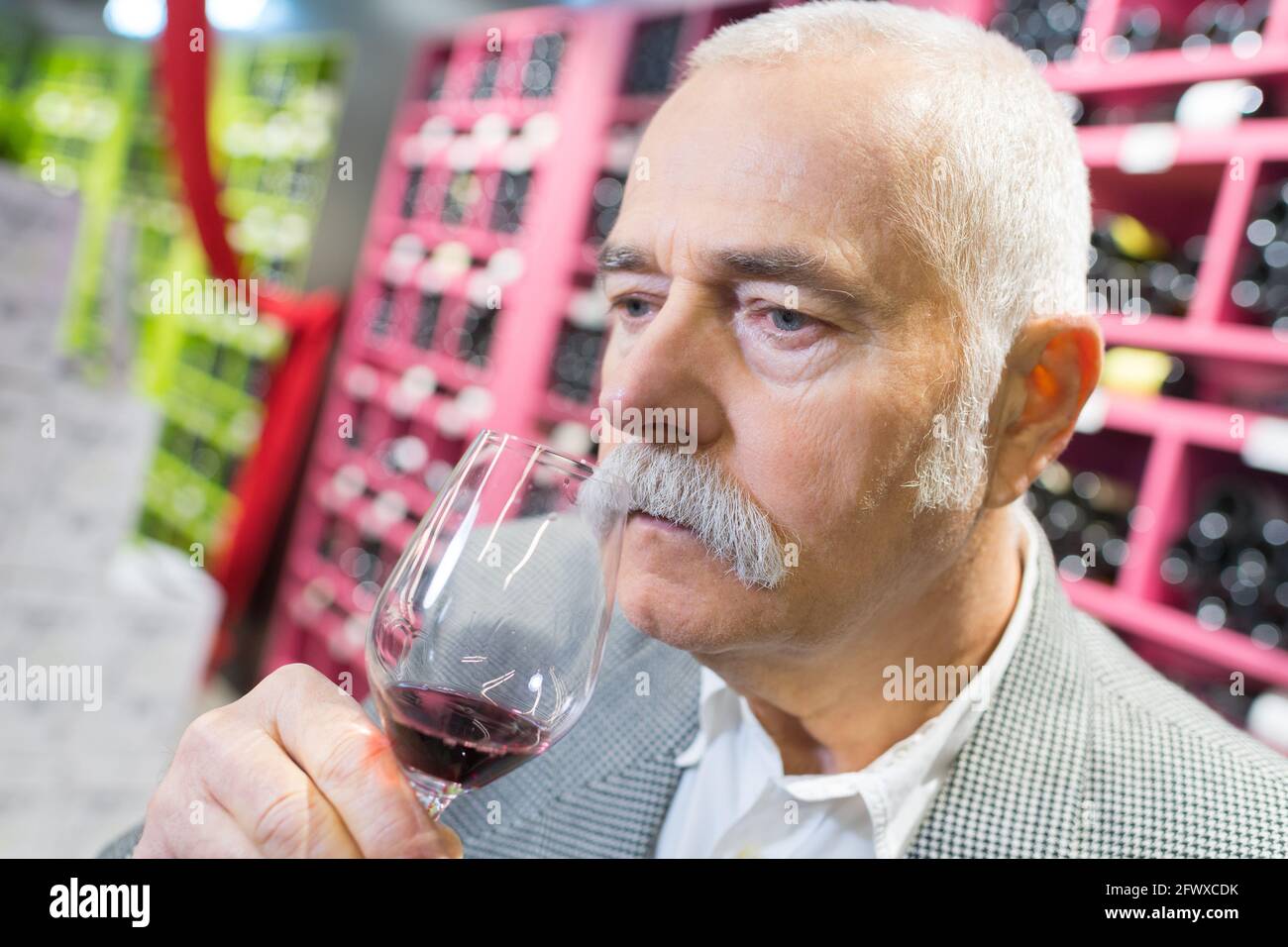senior man drinking red wine from glass at store Stock Photo - Alamy