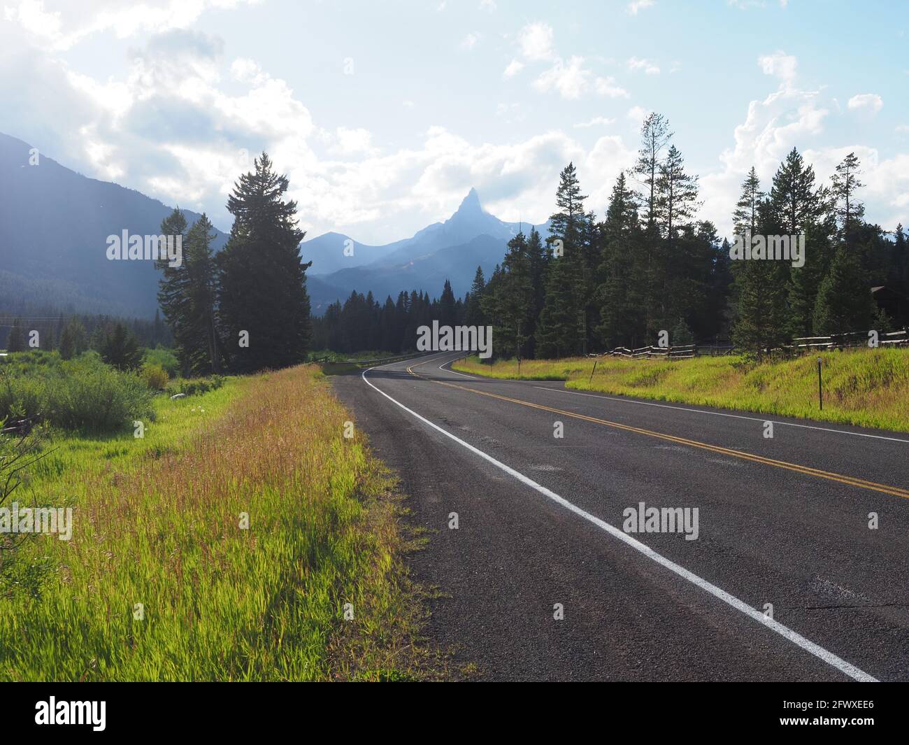 A lonely highway leads towards the Absaroka mountains and Yellowstone National Park Stock Photo
