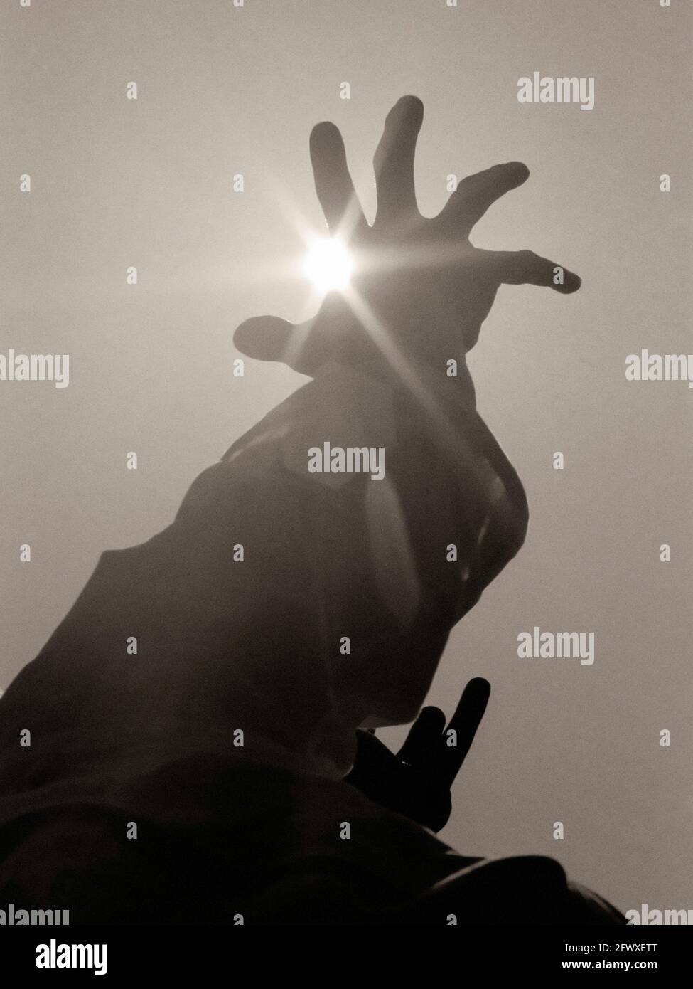 Hand Rises From Sun For Help Hand Raised to Sun For Help Stock Photo - Alamy
