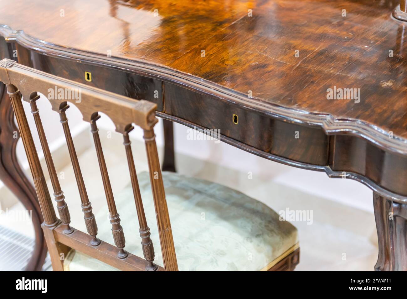 An old table made of expensive wood. Retro furniture set of carved chair and table Stock Photo