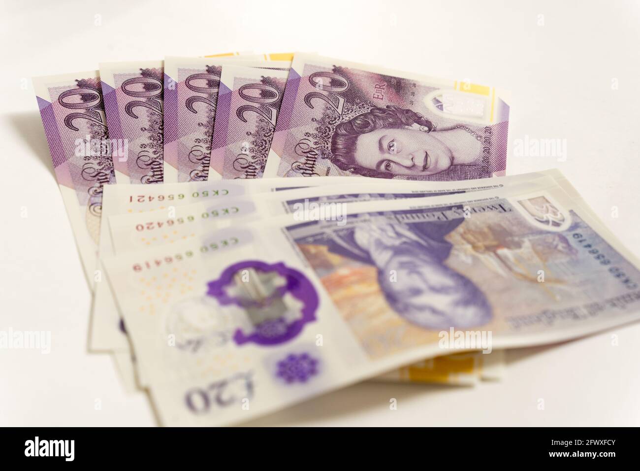stack of sterling pound notes £20 on white background Stock Photo - Alamy