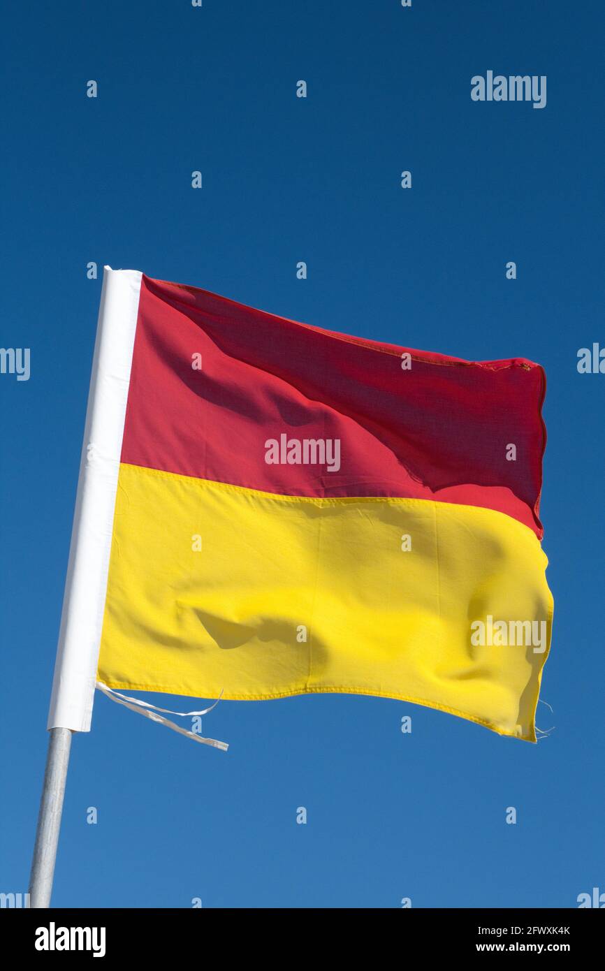 Safety flag flying on a beach on the Gold Coast in Queensland Australia. The flags indicate the area is safe for swimming. Stock Photo