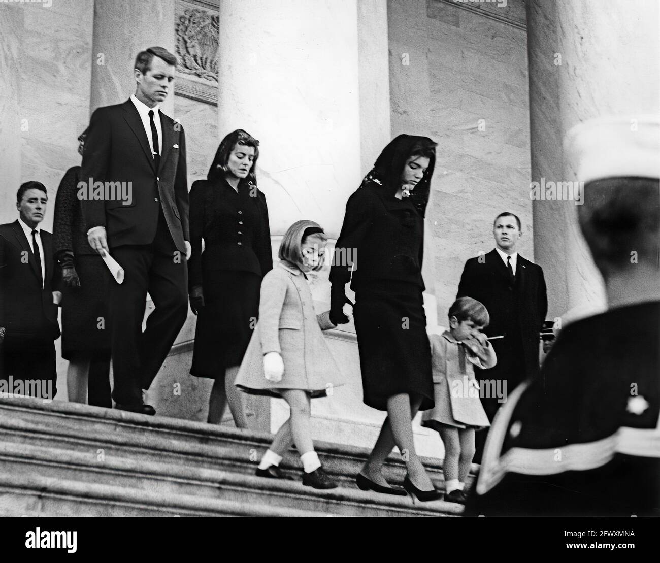 First Lady Jacqueline Kennedy and her children, Caroline Kennedy and John F. Kennedy, Jr., exit the U.S. Capitol Building where the late President John F. Kennedy lies in state. Walking behind: Peter Lawford; Attorney General, Robert F. Kennedy; Patricia Kennedy Lawford. Washington, D.C.. Stock Photo