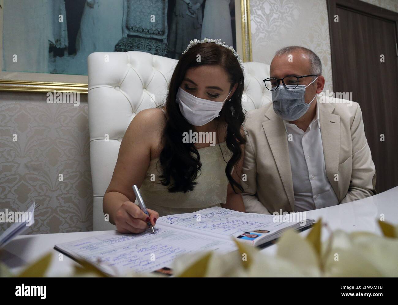 Ankara, Turkey. 24th May, 2021. A couple wearing face masks perform marriage registration during their simple wedding ceremony amid the COVID-19 pandemic in Ankara, Turkey, on May 24, 2021. Credit: Mustafa Kaya/Xinhua/Alamy Live News Stock Photo