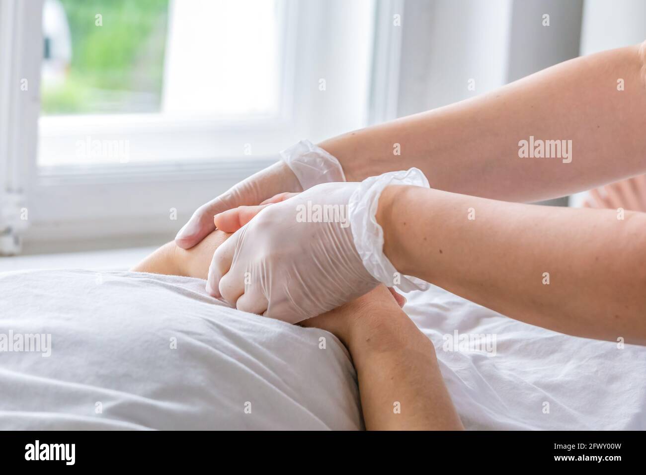 A nurse holding the hands of a sick person, patient Stock Photo
