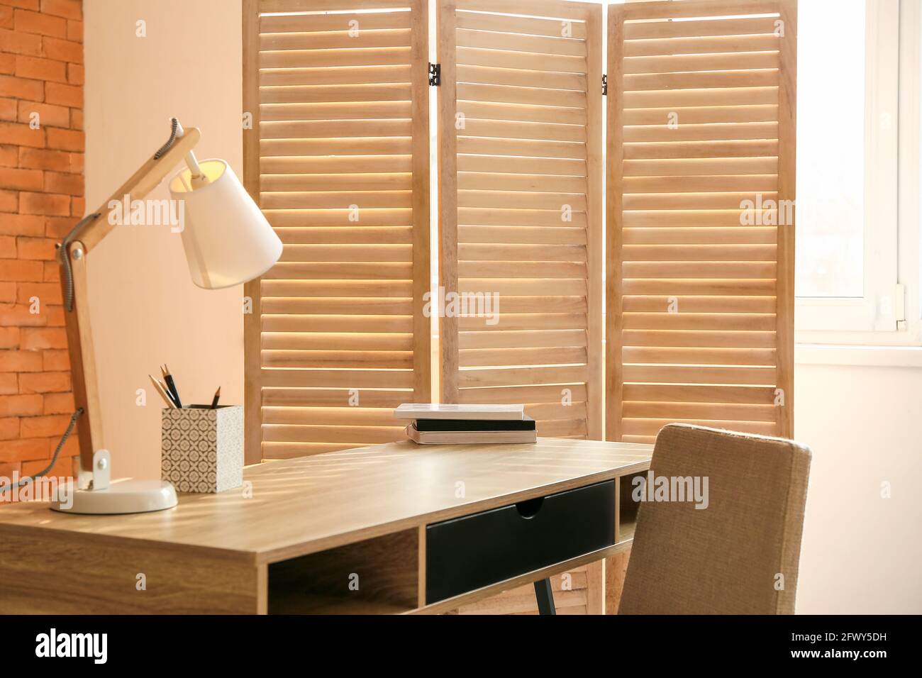Modern workplace and folding screen near window in room Stock Photo - Alamy
