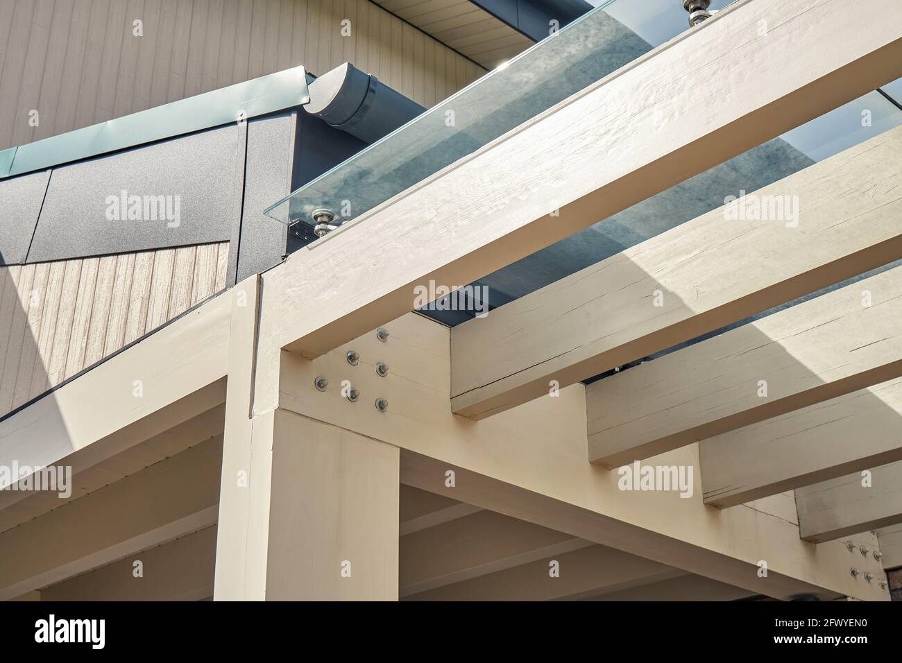 Carcass of comfortable pergola made with plain wooden beams with glass