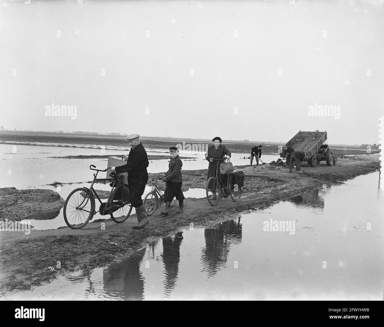 Ouwerkerk freed from isolation after 19 months. The Van Oeveren family on their way back to home in Ouwerkerk on the since a few days dried up and not yet released Molenweg which runs from Stenendijk (Zierikzee) to Ouwerkerk, December 21, 1953, families, floods, flood, The Netherlands, 20th century press agency photo, news to remember, documentary, historic photography 1945-1990, visual stories, human history of the Twentieth Century, capturing moments in time Stock Photo